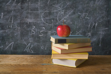 red apple on books with chalk board as background, back to school, education,learning concept