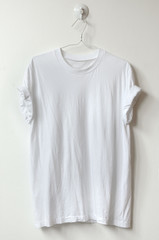 White t-shirt hang on white wall.