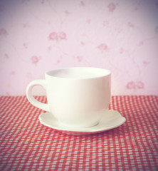 coffee cup on the red color table cloth , Soft pastel effect