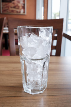 empty glass with ice cubes on wood table