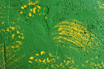 Background of brush strokes of yellow paint on a green wall