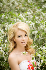 Fototapeta premium Young spring fashion woman. Trendy girl in the flowering trees i