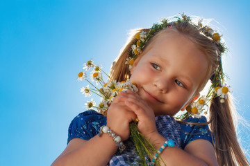 Portrait eines Mädchens mit Kamille im gegenlicht