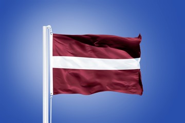 Fototapeta na wymiar Flag of Latvia flying against a blue sky