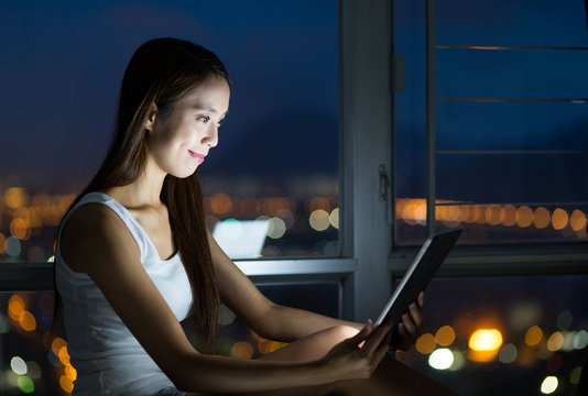 Woman using the digital tablet at night