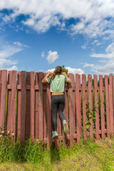 Girl peeking through the fence