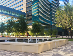 Modern office building with sky bridge and landscaped campus courtyard.