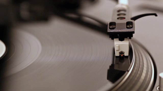 Dj needle stylus on spinning record
