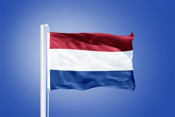 Flag of Netherlands flying against a blue sky