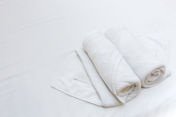 Fototapeta na wymiar Close up of nice white towels on white bed sheet