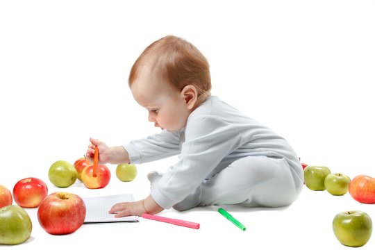 Baby plays with apples. Studio Portrait , isolated on a white background