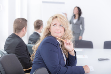 Junge Frau im Blazer langweilt sich im Seminar