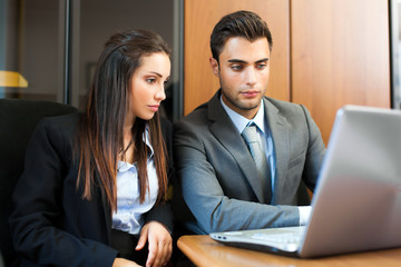 Obraz premium Two young business partners discussing plans or ideas at meeting