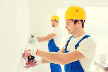 group of builders with measuring tape indoors