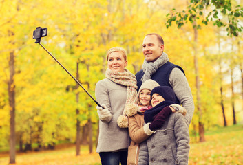 happy family with smartphone and monopod in park