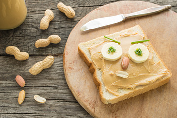 Lustiges Sandwich mit Erdnussbutter als Gesicht