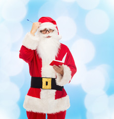 man in costume of santa claus with notepad