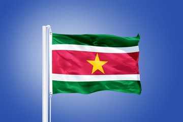 Fototapeta na wymiar Flag of Suriname flying against a blue sky