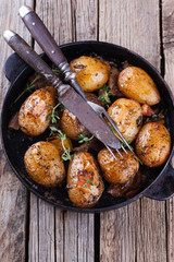 Young potatoes fried in a pan. With garlic, pancetta and thyme.selective focus