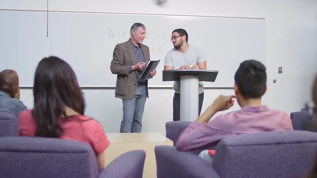 A professor helps his student give his speech
