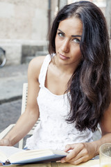 portrait of attractive girl while reading book in a coffee bar