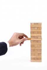 Hand playing with the wood game (jenga). on white background.