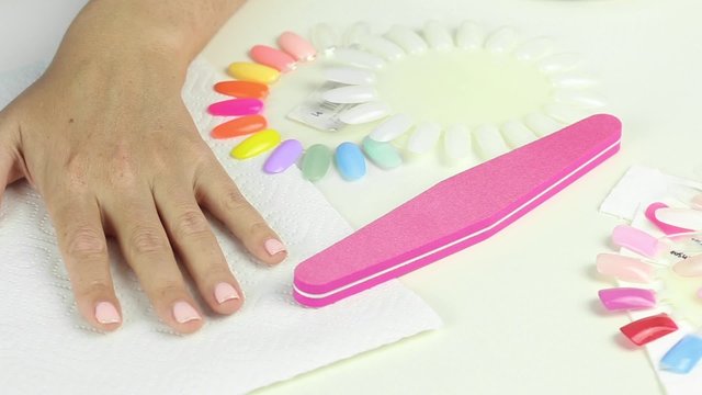 Manicure in process - painting gel polish of pink color on female nails