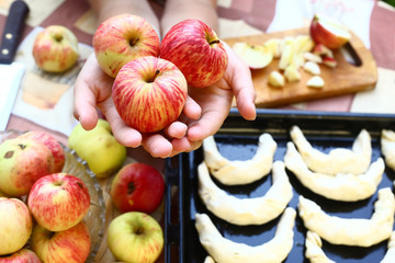 fresh ripe apples  in hands with croissant on the background