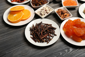 Different products on saucers on wooden table, closeup