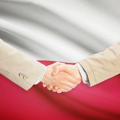 Businessmen handshake with flag on background - Poland
