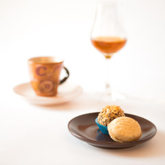 Cup of coffee with chocolate candies and glass of cognac