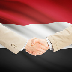 Businessmen handshake with flag on background - Yemen