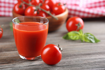 Glass of tomato juice with vegetables on wooden table close up