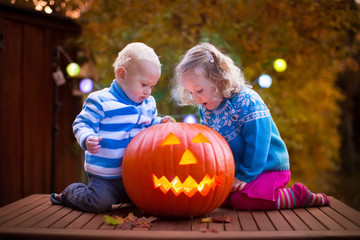 Kids carving pumpkin at Halloween