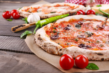 Delicious pizzas on wooden table, closeup