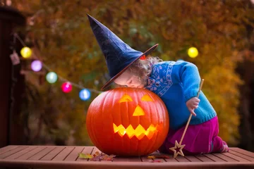 Fototapeten Kids carving pumpkin at Halloween © famveldman