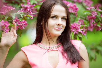 Fototapeta premium Young spring fashion woman. Trendy girl in the flowering trees i