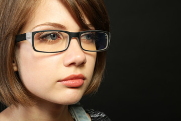Fototapeta premium Attractive young woman with glasses on gray background