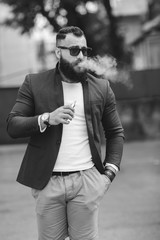 man with a beard smokes electronic cigarette