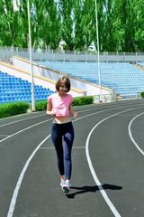 Young woman jogging on stadium