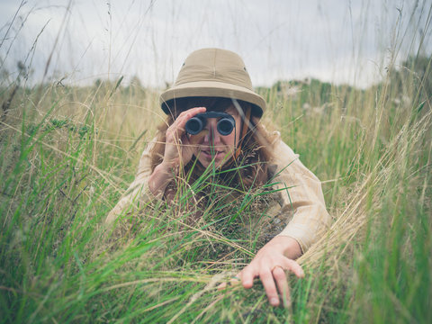 Young woman with binoculars in the grass