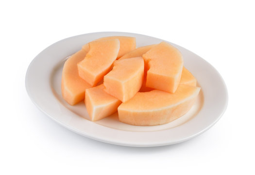sliced cantaloupe melon on white plate on white background