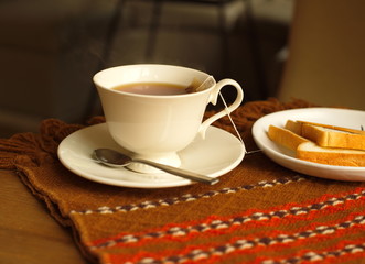 cup of tea with bread on table