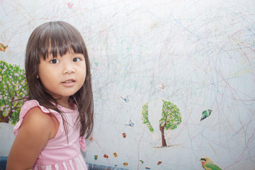 girl drawing with crayons on the wallpaper