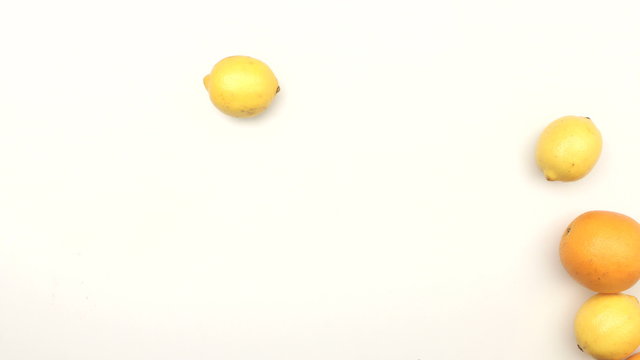 Fresh oranges and lemons moving on white background