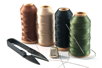 Thimble,needles,spools and scissors for sewing on a background thread