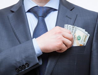 Businessman putting money in the breast pocket