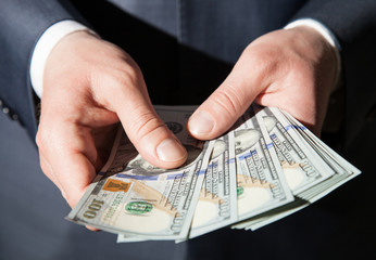 Man's hands holding dollars