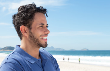 Mann mit Bart am Strand schaut in die Ferne