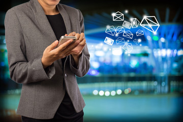 Business woman sending ema byi using mobile phone.